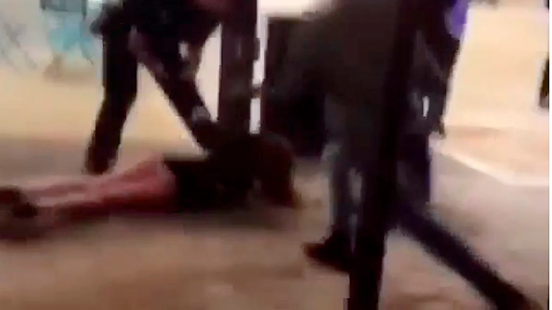 Un policía tumba a una joven en el suelo en plena calle Un policía tumba a una joven en el suelo en plena calle