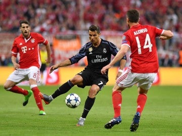 Cristiano Ronaldo intenta avanzar ante la defensa de Xabi Alonso