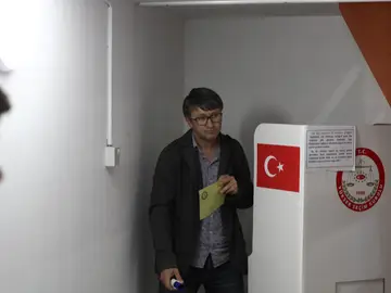 Una persona vota en un colegio electoral Una persona vota en un colegio electoral
