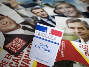 Una credencial para votar es fotografiada sobre los panfletos de los once candidatos