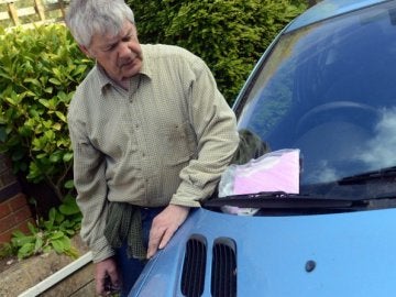 Tom Newey de Chippenham con la tarjeta que encontró pegada a su coche 