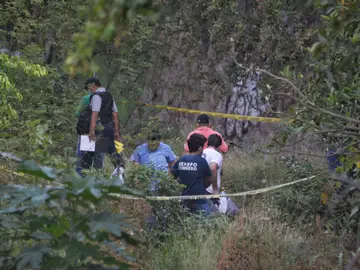Policías federales y personal médico forense inspeccionan el canal de aguas pluviales Policías federales y personal médico forense inspeccionan el canal de aguas pluviales