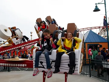 Dos niños montados en una atracción de feria Dos niños montados en una atracción de feria