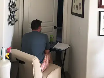 El hombre ha colocado el escritorio en la puerta para estar cerca de su mujer El hombre ha colocado el escritorio en la puerta para estar cerca de su mujer
