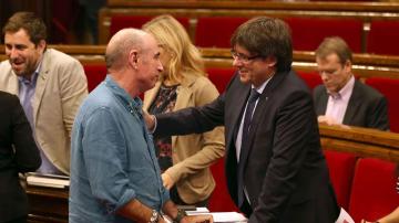 El presidente de la Generalitat, Carles Puigdemont, conversa con el diputado de JxS, Lluís Llach