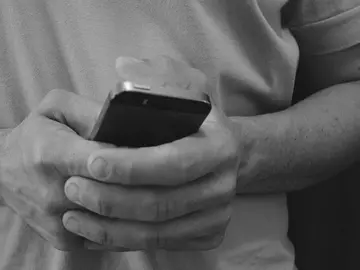 Un usuario con su teléfono móvil Un usuario con su teléfono móvil