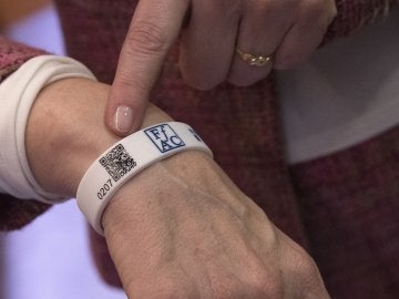 La presidenta de la Federació d'Associacions de familiars d'Alzheimer de Catalunya (FAFAC), Immaculada Fernández, posa con la pulsera de silicona con un código QR