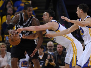 Zaza Pachulia intenta robar el balón a LaMarcus Aldridge