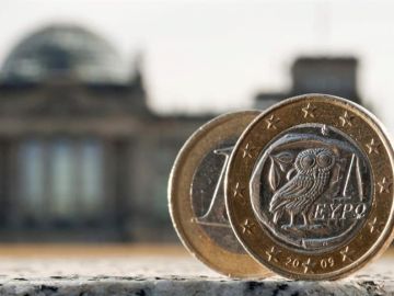 Dos monedas de euro, una de ellas acuñada en Grecia, fotografiadas delante del Bundestag en Berlín (Alemania) Dos monedas de euro, una de ellas acuñada en Grecia, fotografiadas delante del Bundestag en Berlín (Alemania)