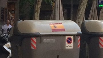 Un cubo de la basura en Cataluña con una pegatina de España