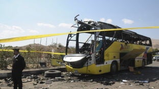 Un polic&iacute;a egipto hace guardia junto al autob&uacute;s que sufri&oacute; un atentado