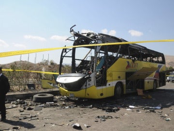 Un policía egipto hace guardia junto al autobús que sufrió un atentado