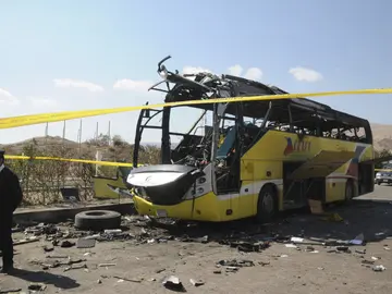 Un policía egipto hace guardia junto al autobús que sufrió un atentado Un policía egipto hace guardia junto al autobús que sufrió un atentado