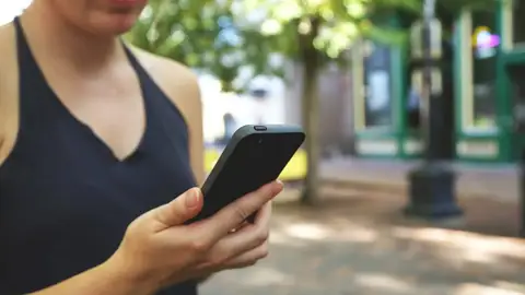 Una mujer observando el móvil Una mujer observando el móvil