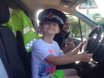 El niño con la gorra de un policía tras llevarles chocolatinas