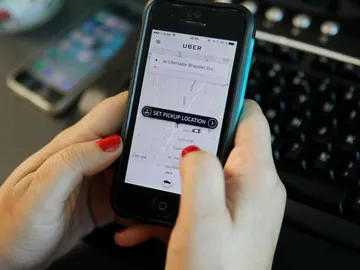 Una persona pide un vehículo a través de la aplicación de Uber Una persona pide un vehículo a través de la aplicación de Uber