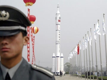 Un guardia de seguridad delante de un modelo de la nave espacial Shenzhou