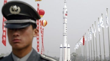 Un guardia de seguridad delante de un modelo de la nave espacial Shenzhou