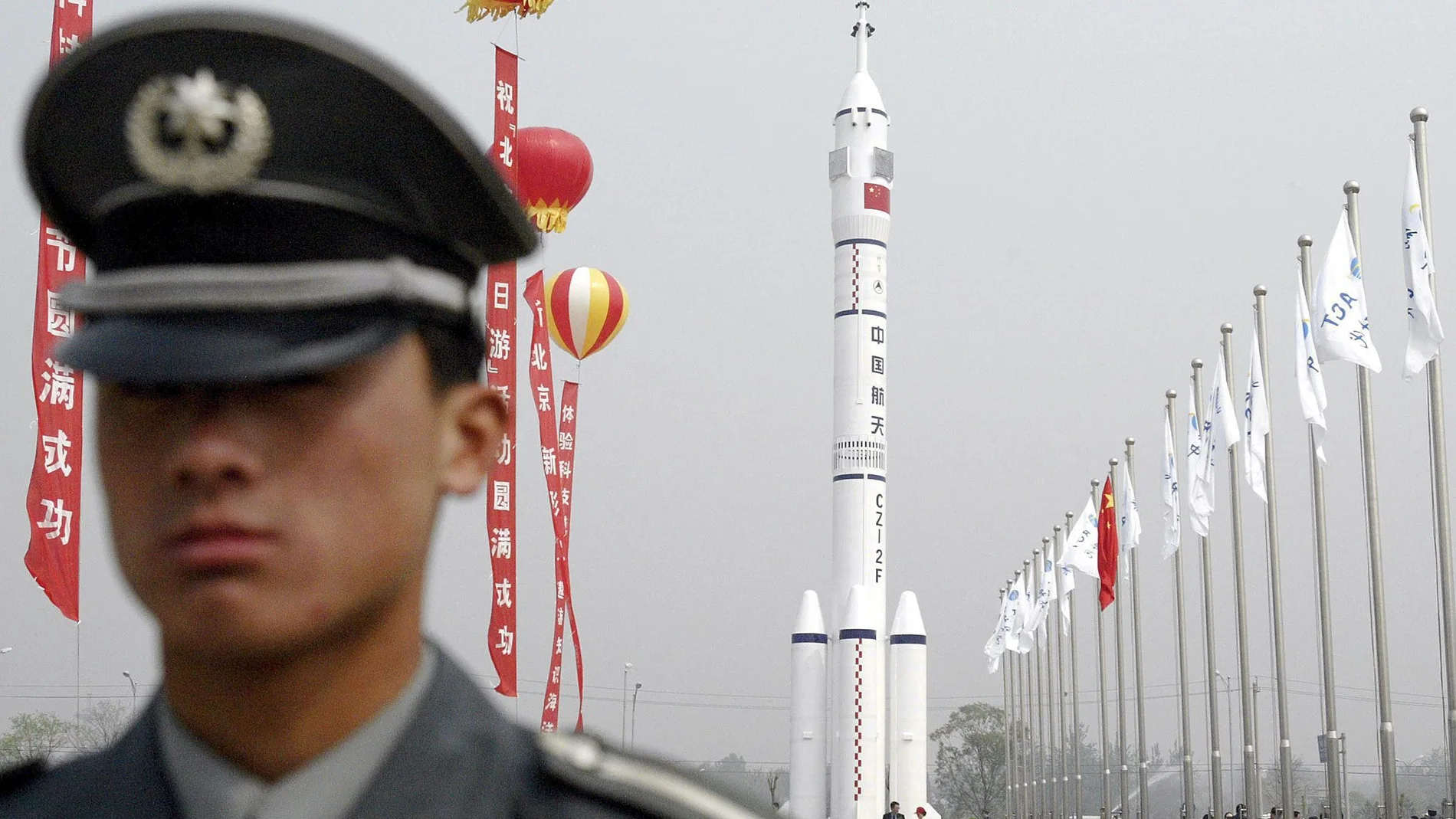 Un guardia de seguridad delante de un modelo de la nave espacial Shenzhou Un guardia de seguridad delante de un modelo de la nave espacial Shenzhou