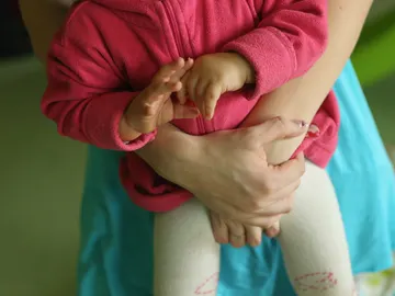 Una mujer sostiene a un bebé Una mujer sostiene a un bebé