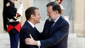 El presidente francés, Emmanuel Macron (i), da la bienvenida al jefe del Gobierno español, Mariano Rajoy