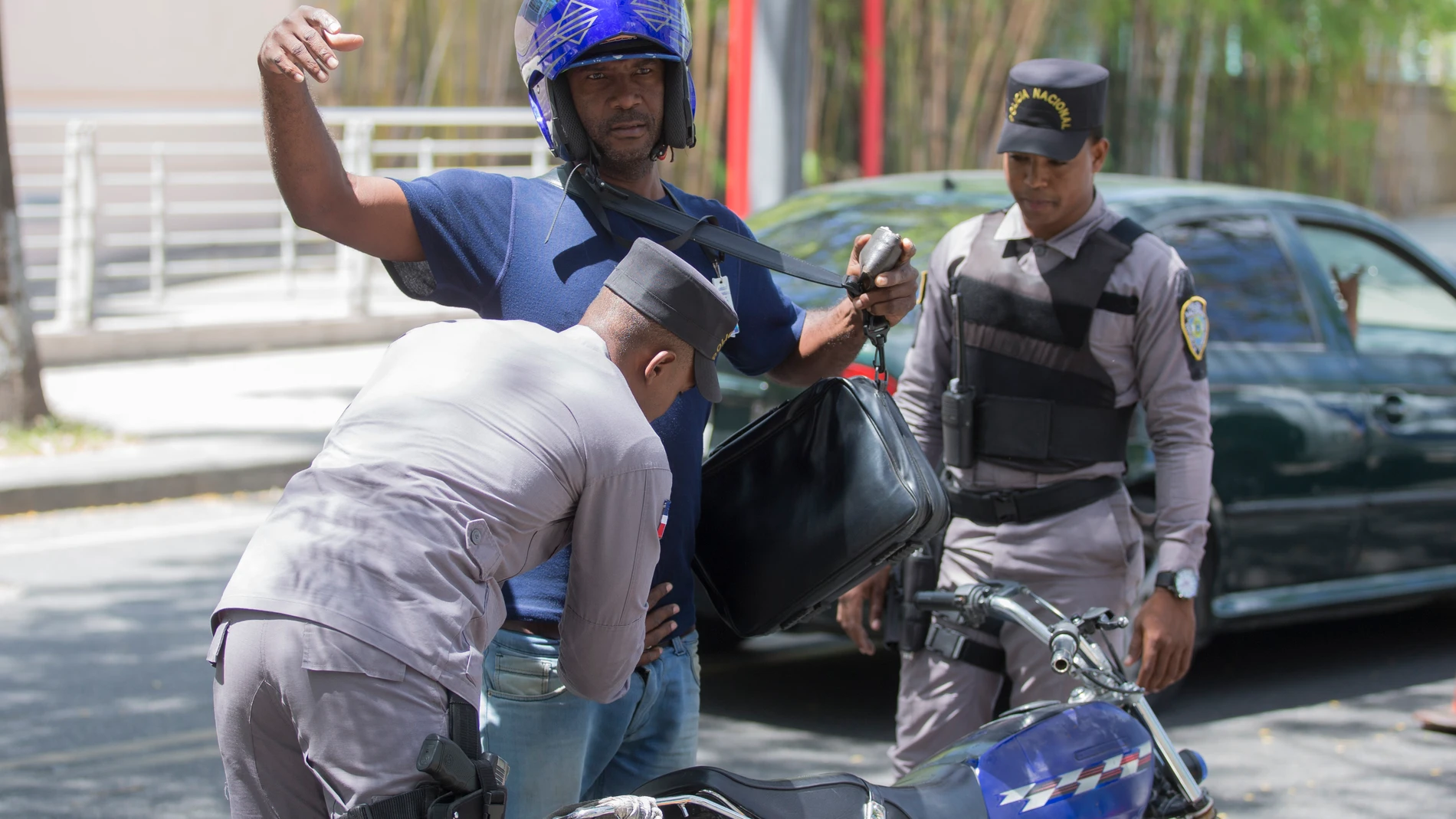 Un agente de seguridad registra a un motorista Un agente de seguridad registra a un motorista