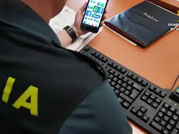 Un agente de la Guardica Civil con un teléfono móvil con acceso a redes sociales Un agente de la Guardica Civil con un teléfono móvil con acceso a redes sociales