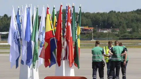Unos operarios esperan junto a banderas y alfombras rojas preparadas en el aeropuerto para la llegada de los líderes Unos operarios esperan junto a banderas y alfombras rojas preparadas en el aeropuerto para la llegada de los líderes
