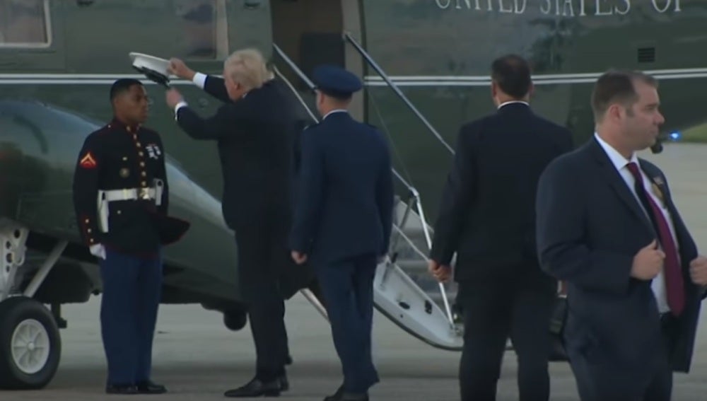 Trump colocándole la gorra al marine