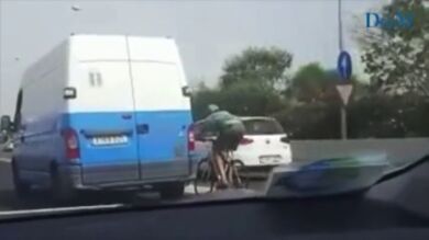 Un ciclista circula, a más de 100 kilómetros por hora, agarrado a una furgoneta