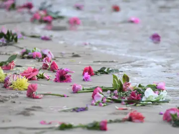 Familiares y amigos se reúnen en la playa Freshwater para hacer una vigilia con velas y flores rosadas en honor a Justine Damond, en Sídney Familiares y amigos se reúnen en la playa Freshwater para hacer una vigilia con velas y flores rosadas en honor a Justine Damond, en Sídney