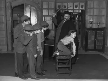 Castigo a un niño con una regla de madera Castigo a un niño con una regla de madera