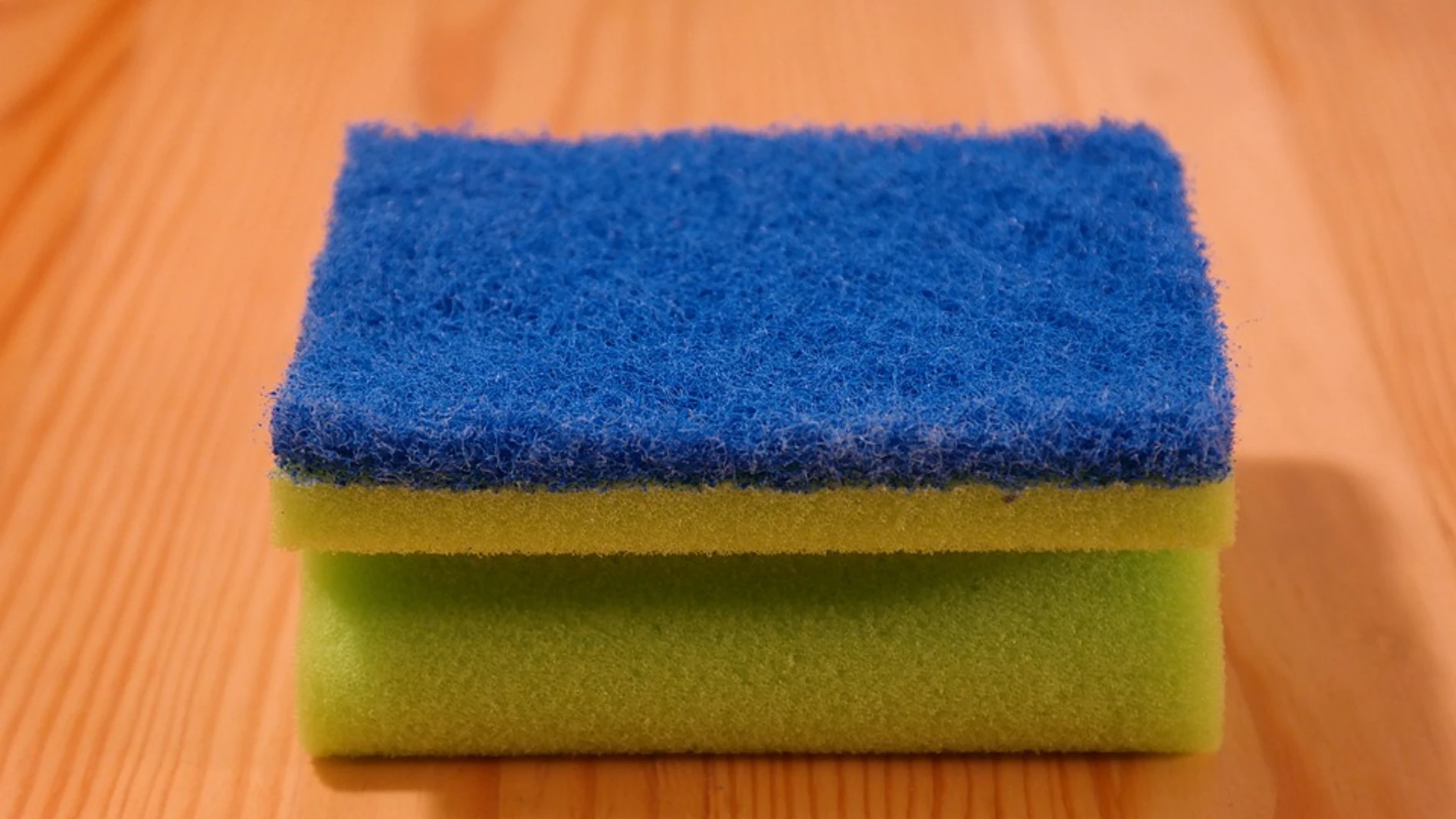 Imagen de un estropajo de cocina apoyado sobre una mesa Imagen de un estropajo de cocina apoyado sobre una mesa