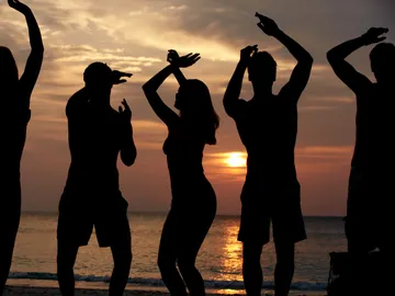 Siluetas de gente bailando en la playa Siluetas de gente bailando en la playa