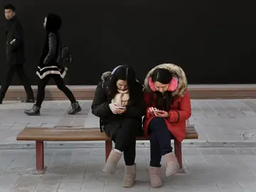 Mujeres chinas mirando su móvil Mujeres chinas mirando su móvil