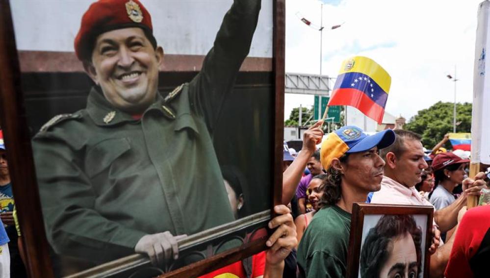 Chavistas participan en una manifestación con un cuadro del fallecido presidente Hugo Chávez