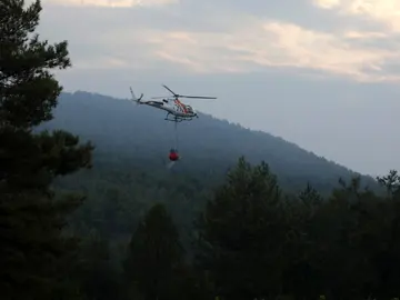 Un helicóptero trabaja en las labores de extinción del incendio forestal declarado en el municipio de Artés (Barcelona) Un helicóptero trabaja en las labores de extinción del incendio forestal declarado en el municipio de Artés (Barcelona)