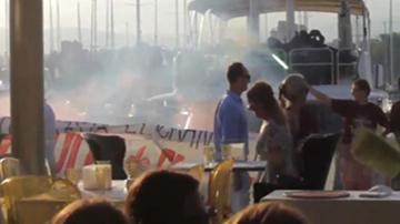 Activistas antisistema se plantan ante un restaurante del puerto de Palma con bengalas