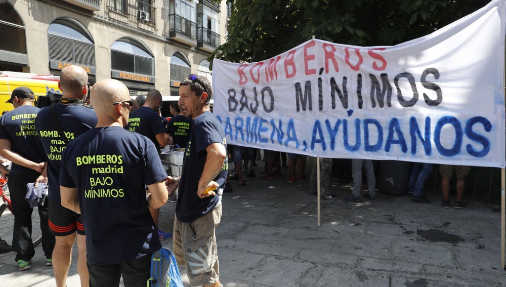 Los Bomberos de Madrid despliegan una pancarta antes de la misa solemne en honor a la Virgen de la Paloma
