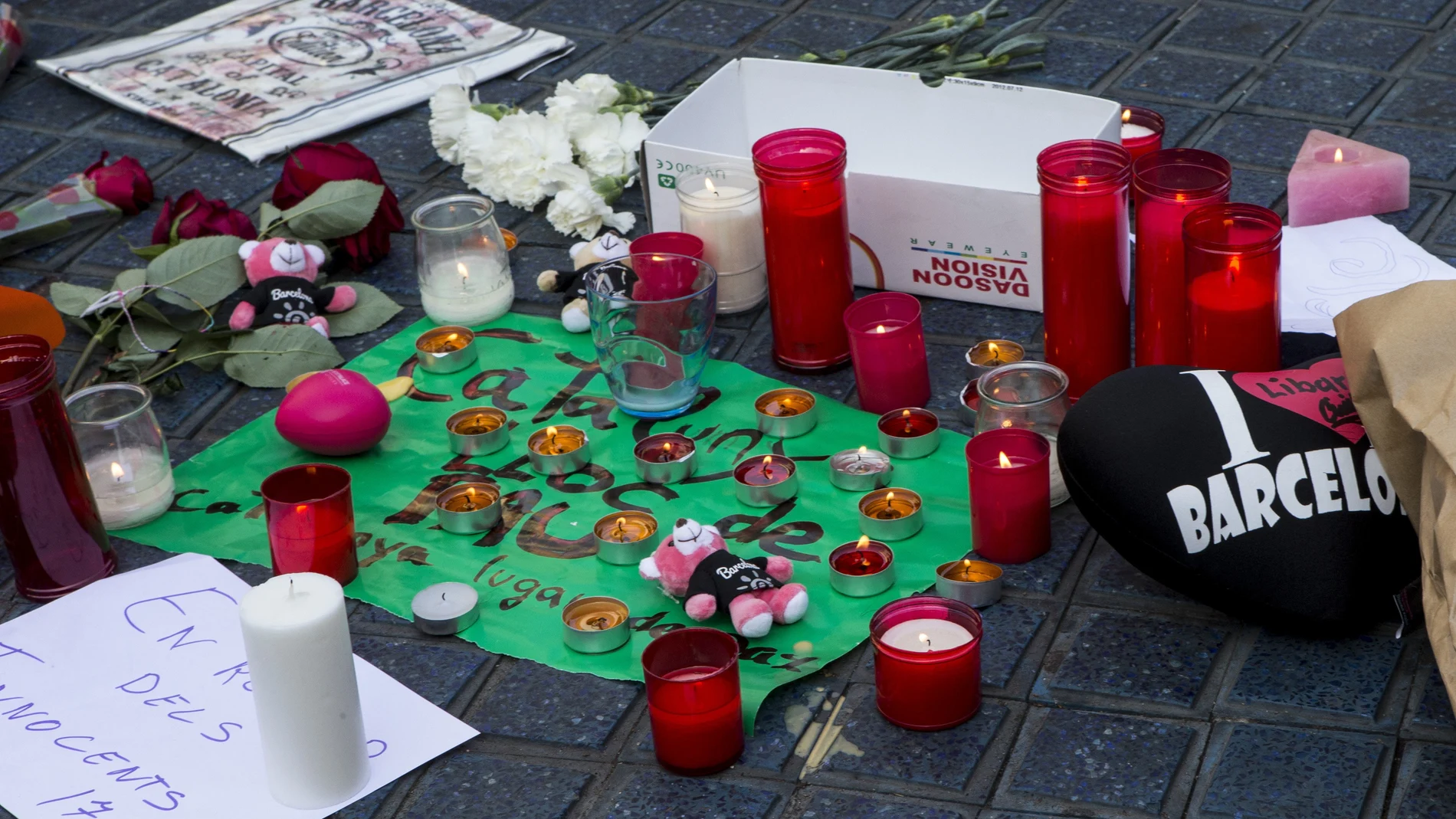 Varios transeúntes depositan mensajes y velas en el mosaico de Miró en las Ramblas Varios transeúntes depositan mensajes y velas en el mosaico de Miró en las Ramblas