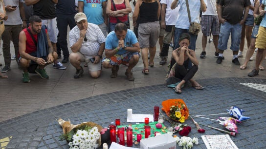 Varias personas se paran frente al mosaico de Mir&oacute; en las Ramblas de Barcelona
