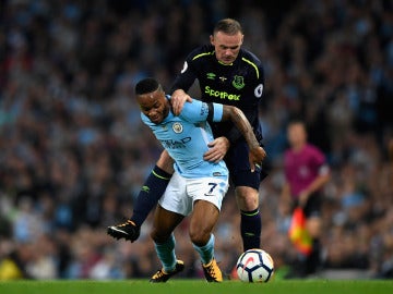 Sterling protege el balón ante Wayne Rooney