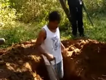 Captura del Jóven cavando, detrás de él un hombre armado Captura del Jóven cavando, detrás de él un hombre armado
