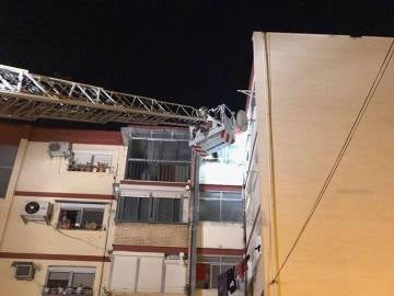 Los bomberos rescatando a la familia encerrada en el cuarto de su hija en Sevilla