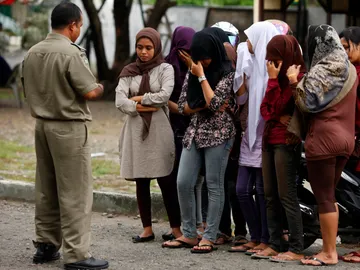 Imagen de archivo de un policía de la sharía aleccionando a unas jóvenes, en Indonesia Imagen de archivo de un policía de la sharía aleccionando a unas jóvenes, en Indonesia