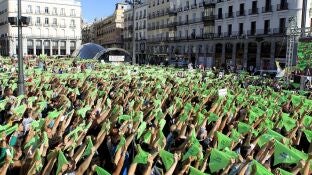 Miles de personas convocadas por el Partido Animalista Pacma, en la Puerta del Sol de Madrid, portan pa&ntilde;uelos verdes para simular un "chupinazo animalista" en una manifestaci&oacute;n contra la tauromaquia 