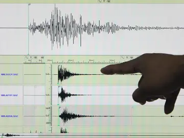 Un experto señala en un sismógrafo el registro de un terremoto Un experto señala en un sismógrafo el registro de un terremoto
