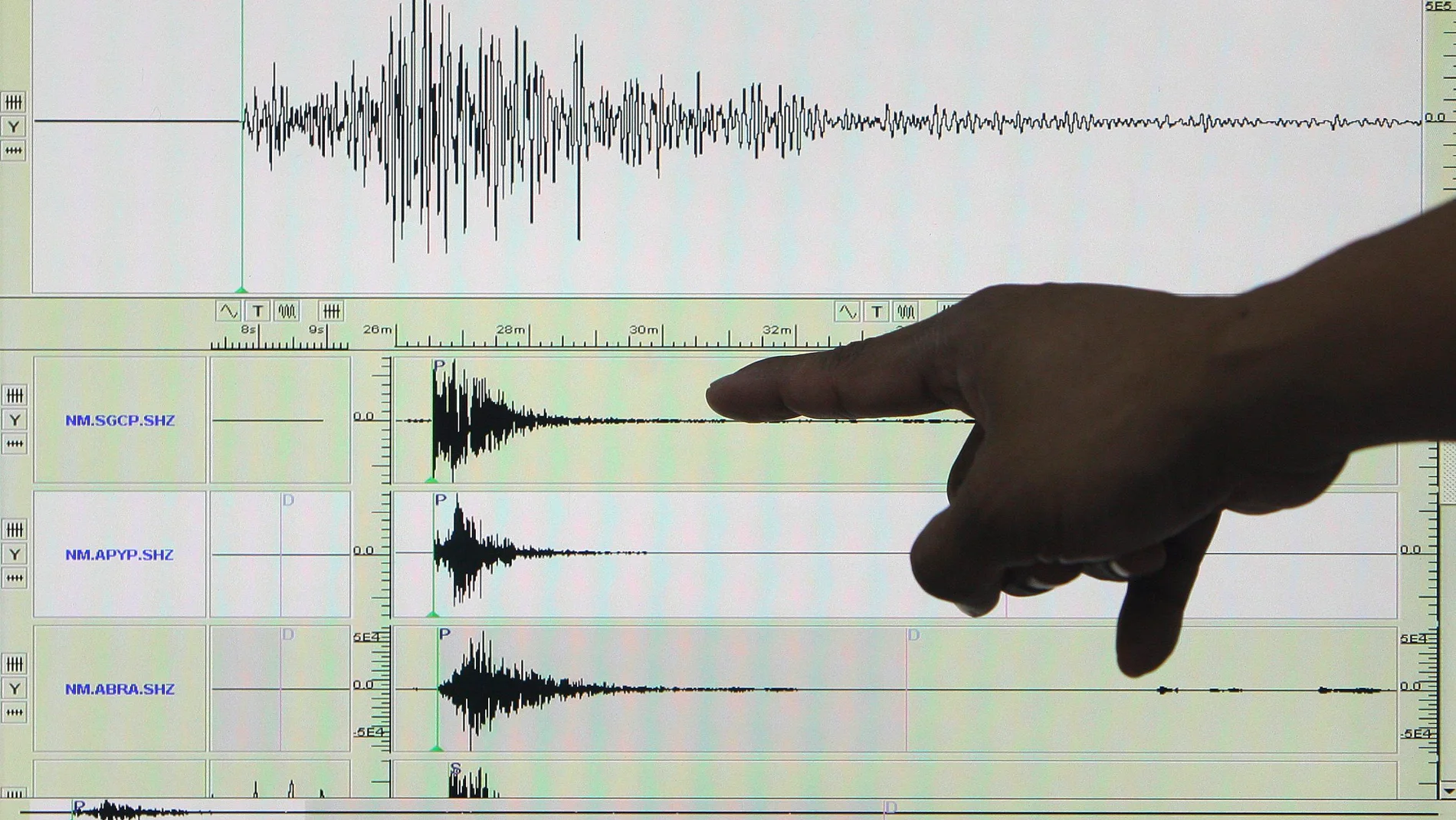 Un experto señala en un sismógrafo el registro de un terremoto Un experto señala en un sismógrafo el registro de un terremoto