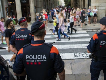Efectivos del cuerpo de Mossos d'Esquadra patrullan por Barcelona