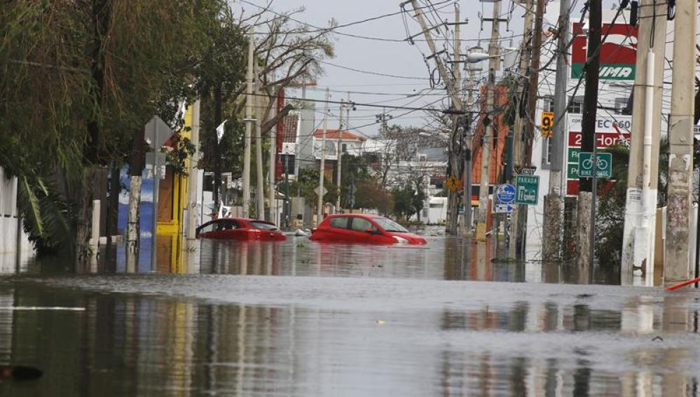  Dos coches flotan en una calle totalmente inundada en San Juan (Puerto Rico), tras el paso del huracán María.